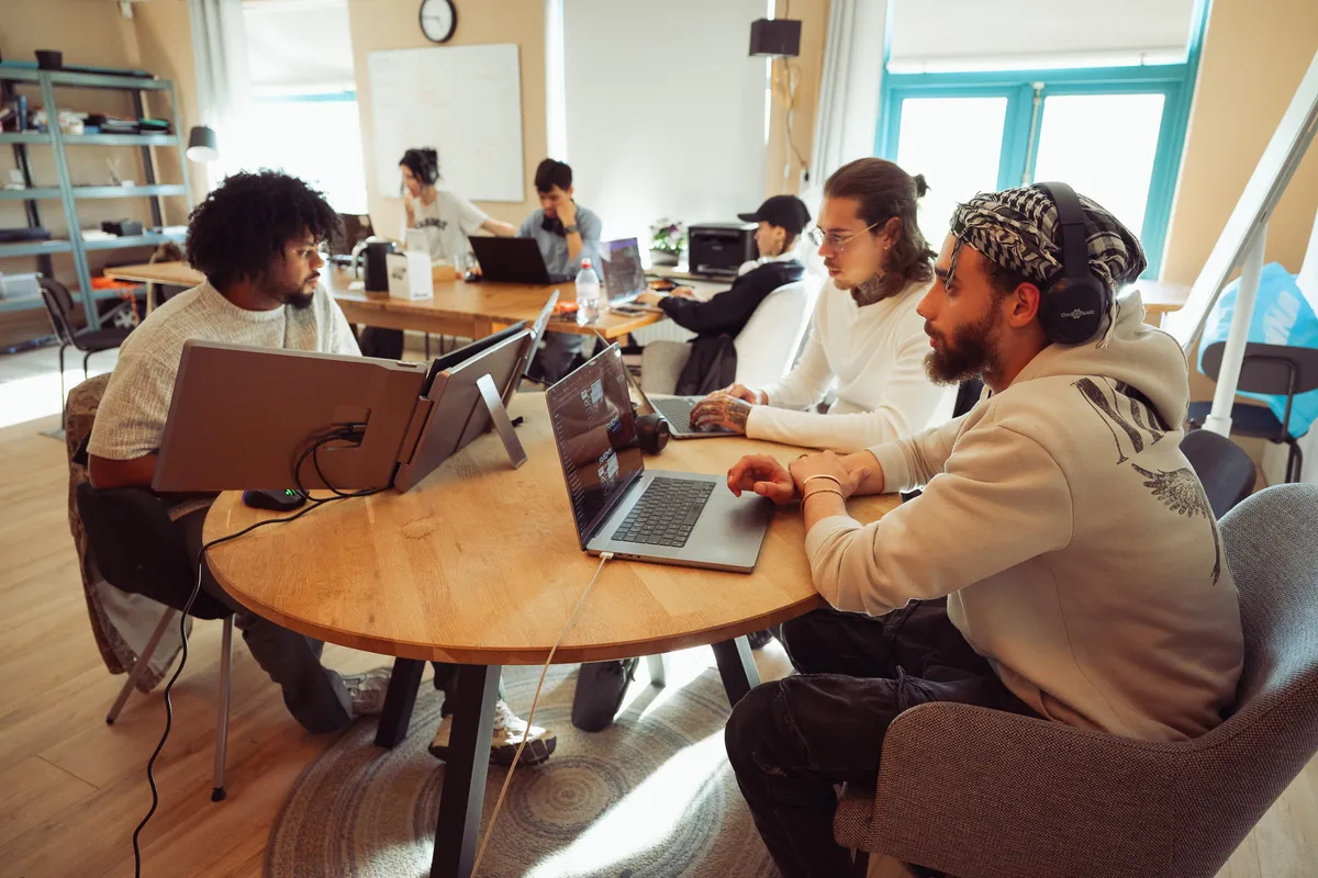 Mensen werken samen op hun laptop aan ronde tafels in de multifunctionele creative space