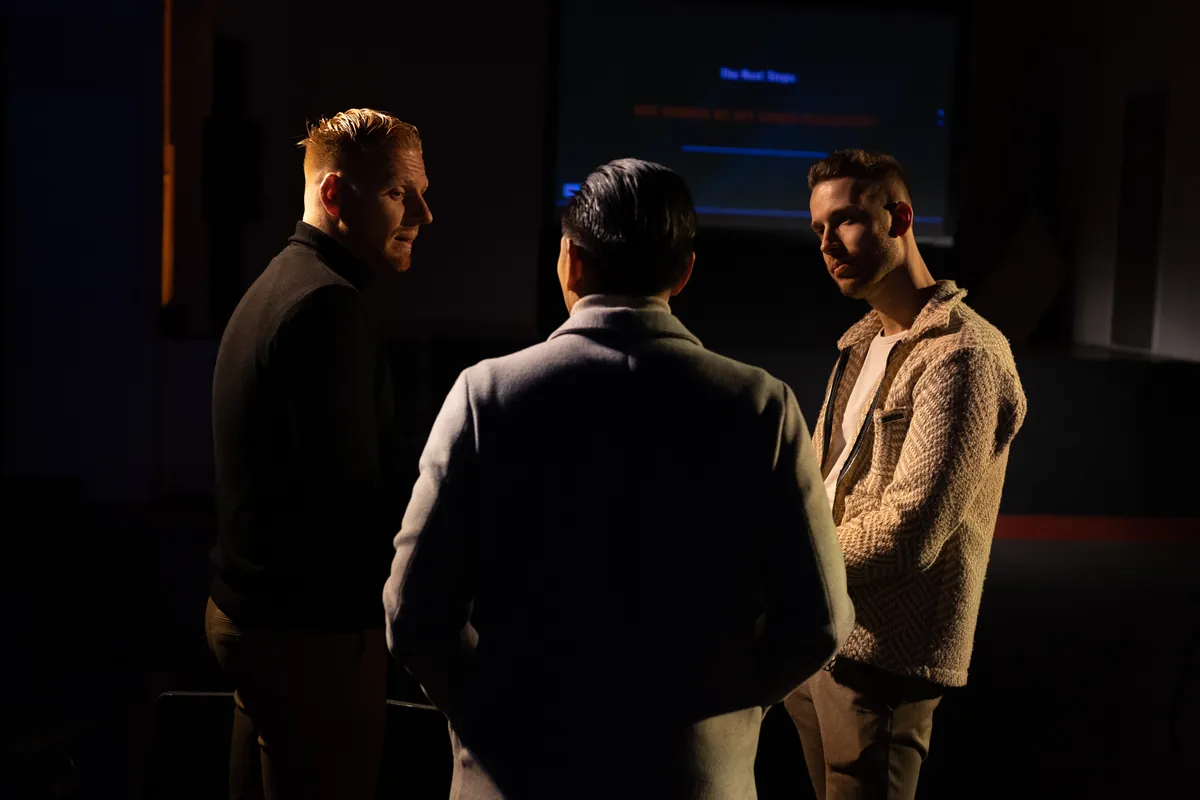 Drie mannen in gesprek in de zaal tijdens The Next Steps