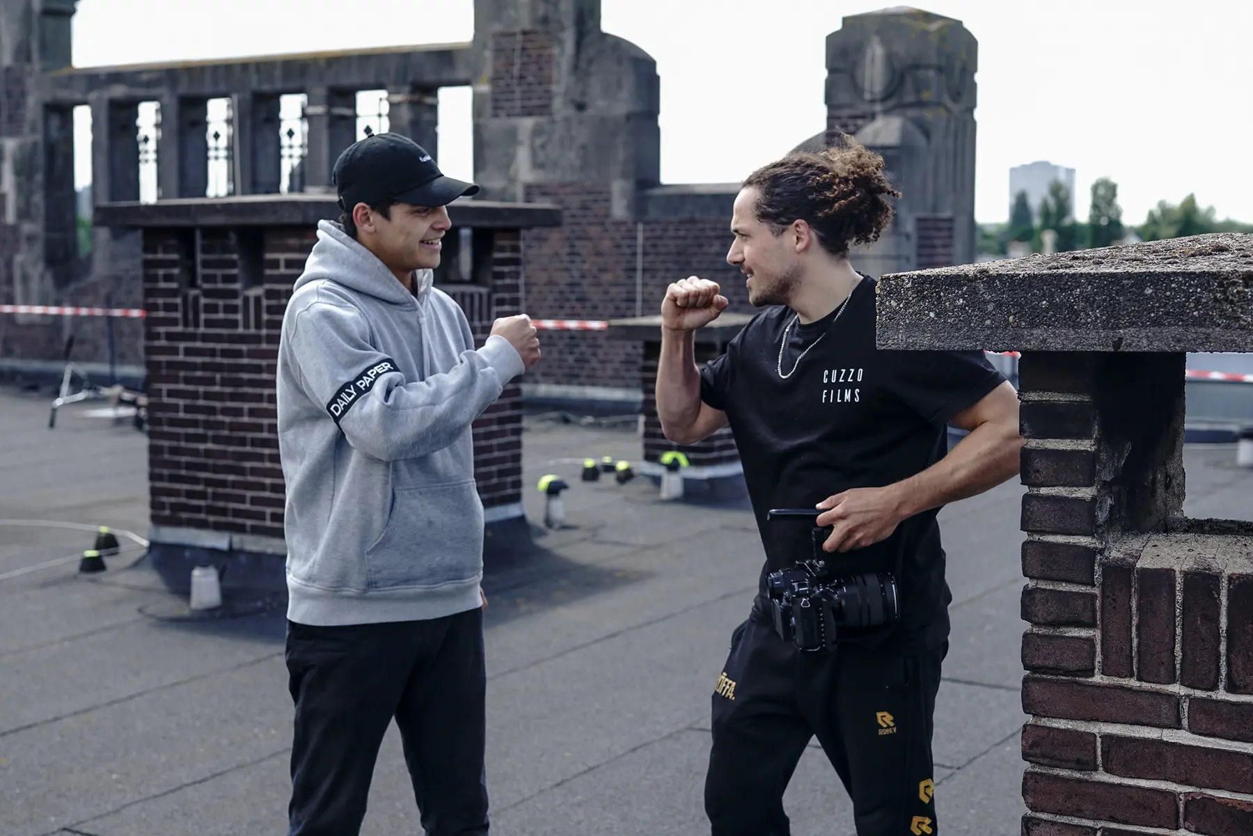 Fistbump op een dak tijdens een filmopname