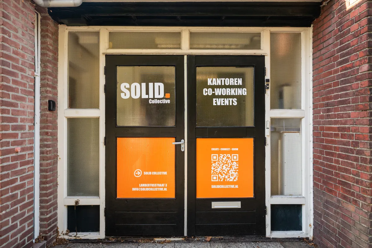 De voordeur van SOLID aan de Lambertusstraat 3 met oranje posters